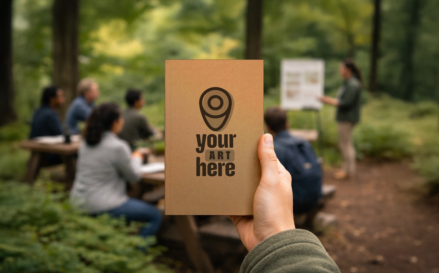 Hand holding custom eco-friendly notebook at outdoor nature educator breakout session